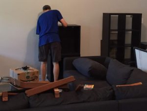 Photo of Kyle setting up the furniture in the new house